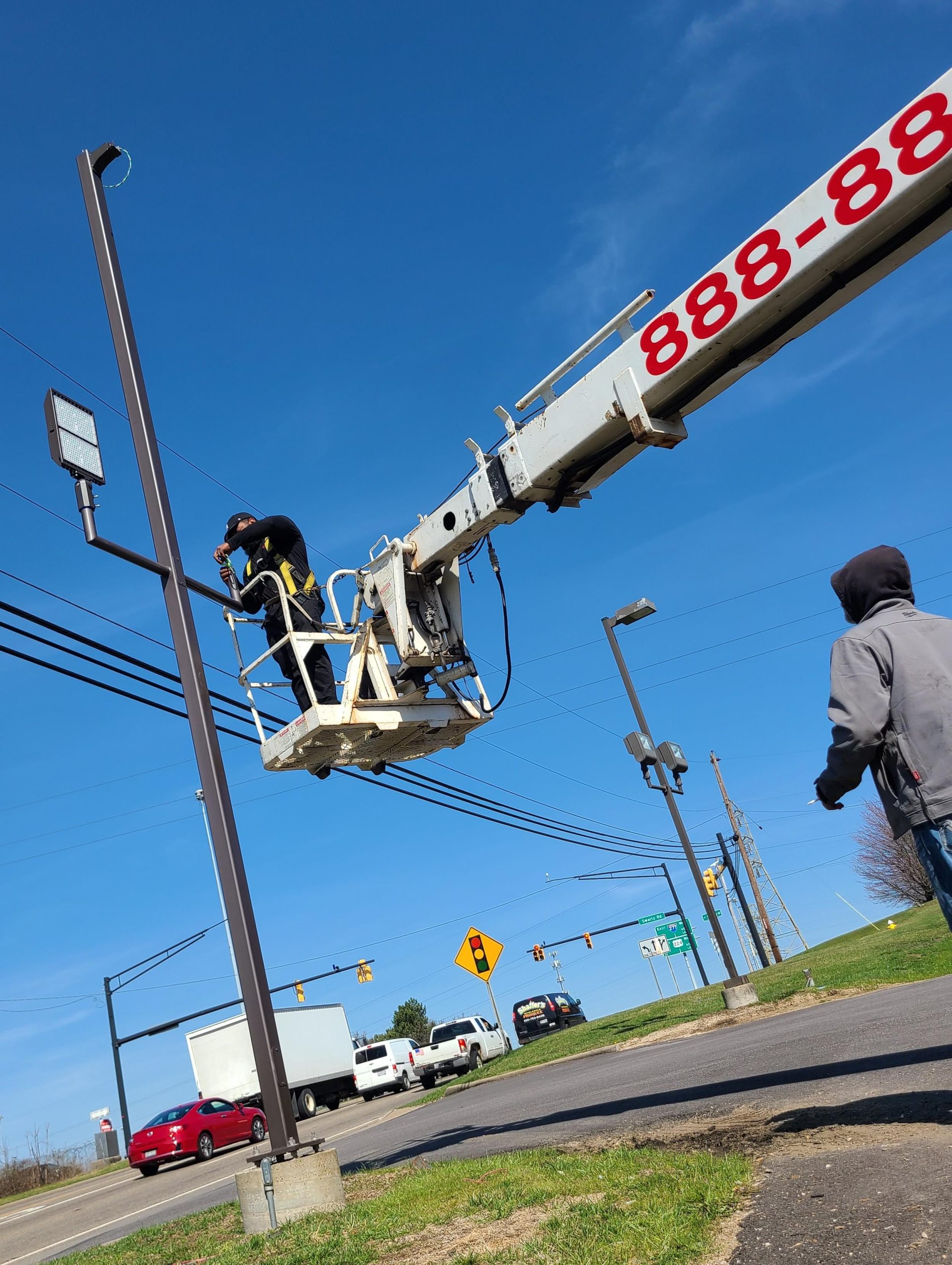 Image of a custom-designed parking lot light pole by Adams Signs, showcasing its utility and security features. Adams Signs also specializes in the installation of customer-provided light poles and foundations for flag poles.