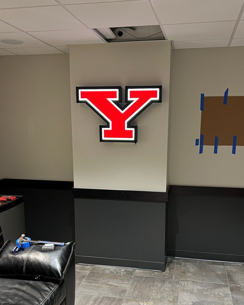 "Image of a Youngstown State University logo wall sign, displaying the school's modern design aesthetic and showcasing YSU pride. The sign's prominent placement emphasizes the university's brand and identity."