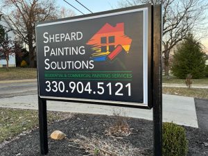 Black post and panel signs for Shepard Painting Solutions with house and paint roller logo.