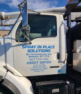 A white work truck with blue applied vinyl lettering of the company's name by Adams Signs