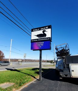 Electronic message center installed under existing pole signage for Loki Ugly Duck in Wooster, Ohio.