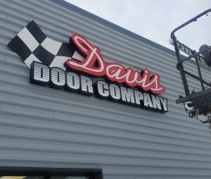 Exterior illuminated wall sign installed by Adams Signs & Graphics for Davis Door in Norton, Ohio.
