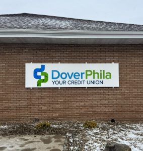 Aluminum wall sign with flat-cut acrylic lettering for DoverPhila Credit Union in New Philadelphia, Ohio, fabricated and installed by Adams Signs & Graphics.