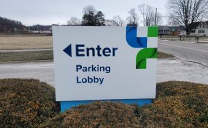 Adams Signs & Graphics installing flat routed aluminum directional sign faces with printed graphics for customer navigation at Dover Phila, Newcomerstown, Ohio.