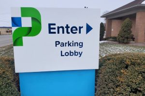 Adams Signs & Graphics installing flat routed aluminum directional sign faces with printed graphics for customer guidance at DoverPhila, Newcomerstown, Ohio.