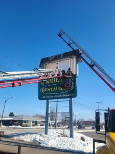 Adams Signs technician in aerial lift removes the Variety's Restaurant cabinet sign face from a pole-mounted structure during a sign face replacement in Massillon, Ohio