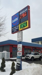 Pole-mounted LED fuel price sign for Louisville Clark Food Mart displaying regular and diesel prices with Clark branding panel and convenience store messaging in Louisville, Ohio