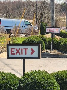 Dunkin' branded exterior directional signs including an Exit sign and Drive Thru pointer installed in a landscaped parking lot in Poland, Ohio | Adams Signs & Graphics