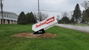 Custom angled specialty sign for Instant Whip Foods displaying the brand logo and address number 4870 on a black base, freshly installed at their Akron, Ohio facility | Adams Signs & Graphics