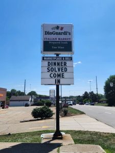Illuminated pylon sign for DioGuardi's Italian Market with a changeable message reader board reading Dinner Solved Come In along a Canton, Ohio roadside | Adams Signs & Graphics